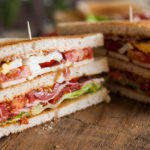 Freshly made clubsandwiches served on a wooden chopping board