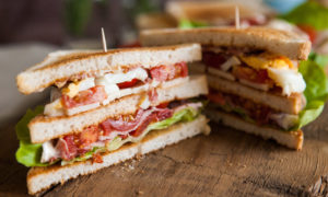 Freshly made clubsandwiches served on a wooden chopping board